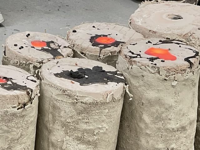 Filled casting flasks with molten bronze glowing at the top