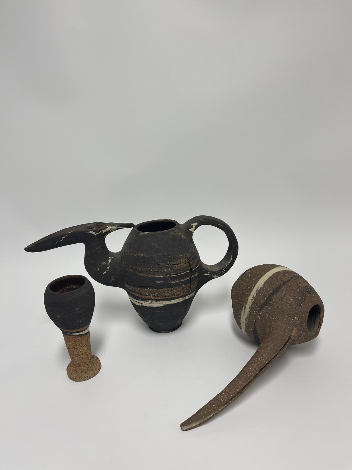 Marlik Vessels — a long-spouted marbled black vessel, a small goblet and a second brown spouted vessel, grouped together