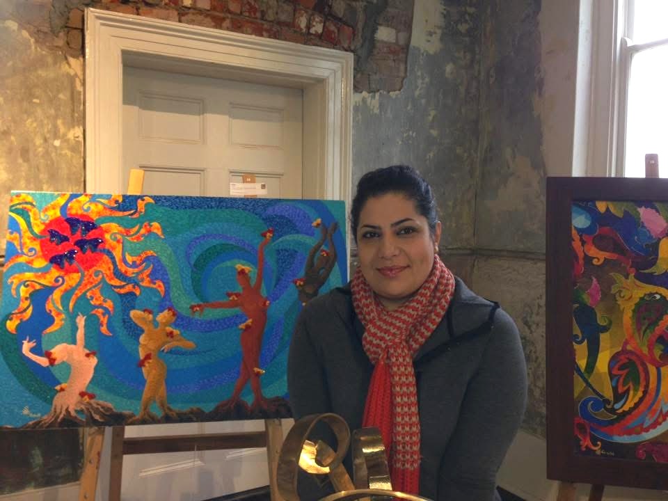 Saideh Mirzai Dodangeh seated beside her paintings and sculpture at the Persian Fair, Abbotsford Convent, Melbourne, 2016