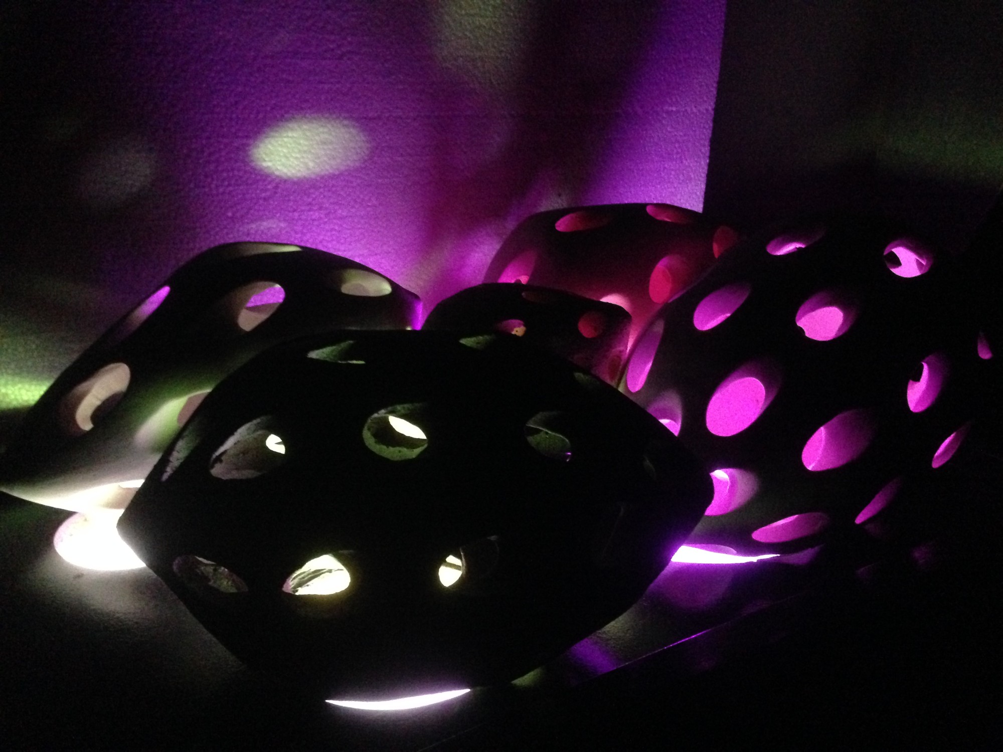 The Touch of Memory — close view of the forms in violet light, the openings glowing pink