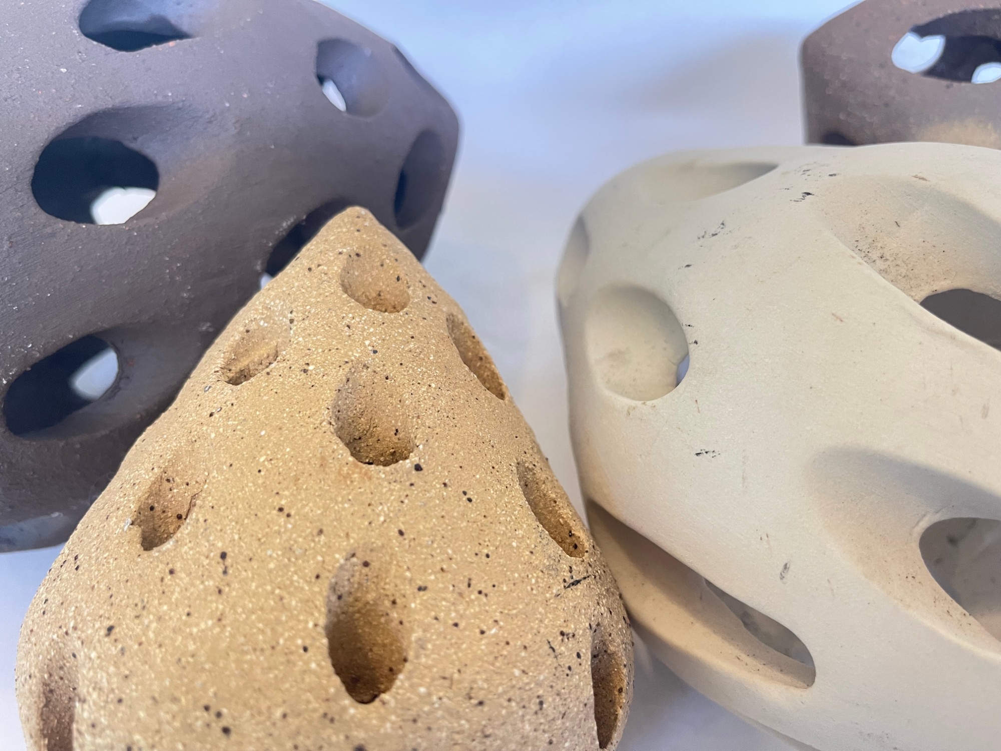 The Touch of Memory — close view of three clay surfaces and their pierced openings